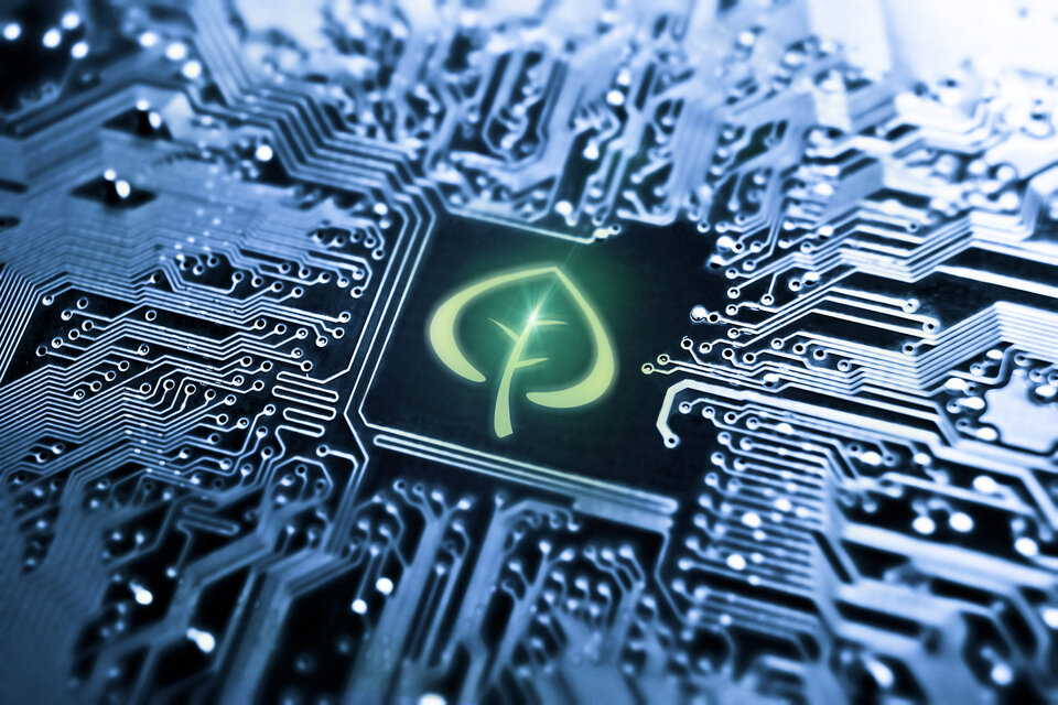 A close-up of a printed circuit board is shown, with a green leaf placed in the centre to represent environmentally friendly electronics cleaning. | © @Zestron