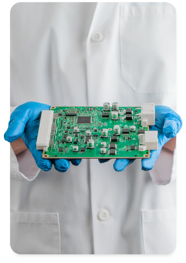 engineer holding a printed circuit board in lab coat