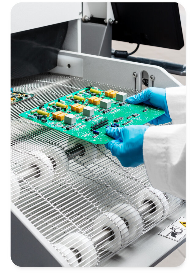 engineer putting pcb into a inline cleaning machine